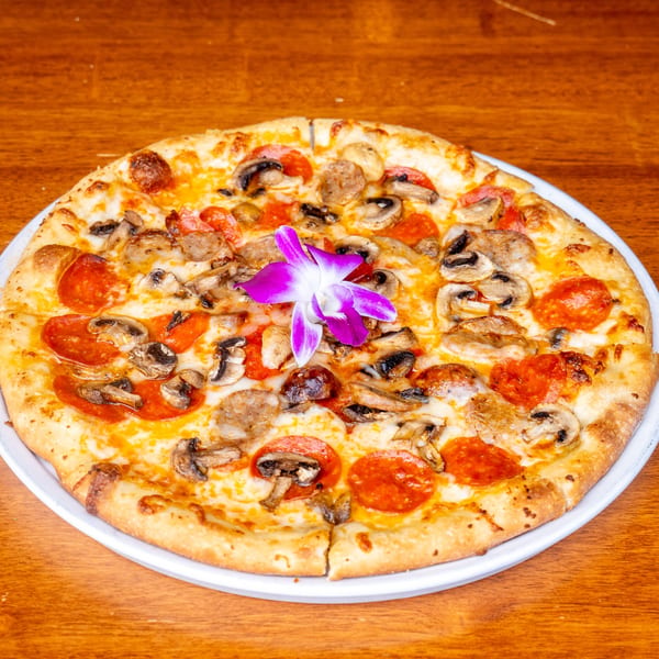 Mona Lisa Cucina's pepperoni, mushroom, and sausage pizza, garnished with a purple orchid.