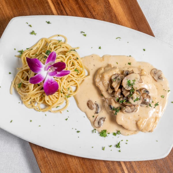 Mona Lisa Cucina's chicken with mushroom cream sauce, spaghetti, and a purple orchid garnish.
