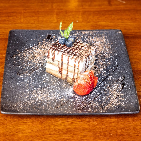 Mona Lisa Cucina's tiramisu, topped with blueberries, mint, chocolate drizzle, and a strawberry.