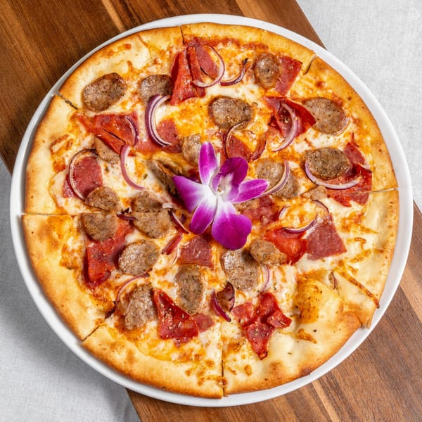 Mona Lisa Cucina's Italian pizza, topped with sausage, pepperoni, red onions, and a purple orchid.